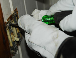 Jonathan takes apart a dual switch. In this job, he wired both lights to one switch. An outlet in the bathroom had run off one switch, but he wired it independently. He replaced this switch with a single switch and an outlet.